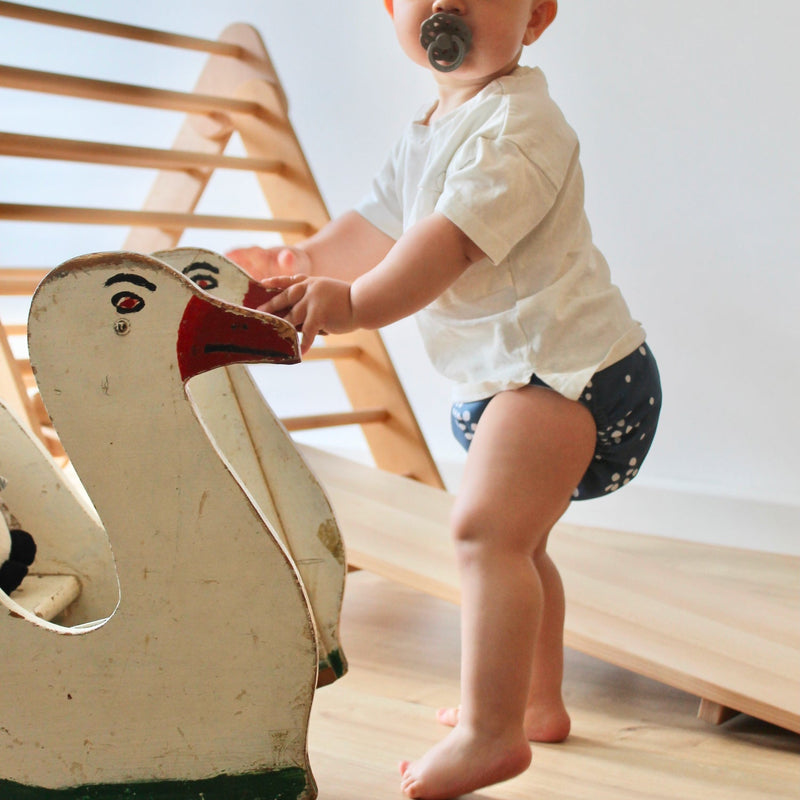 Judes Baby in Stoffwindel mit Holzente Kletterdreieck