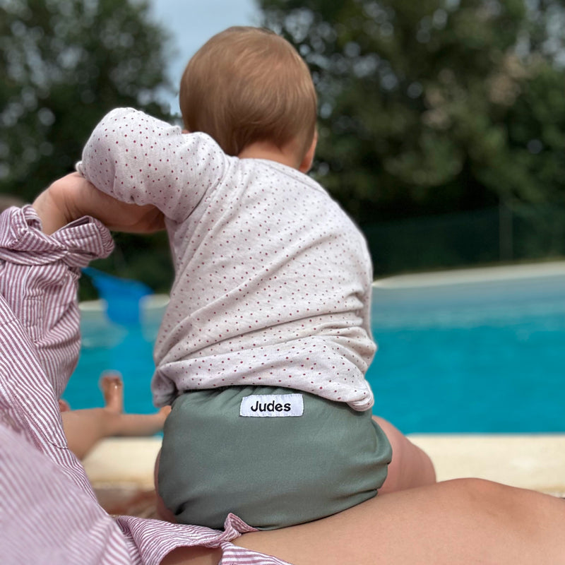 Judes Baby auf Schoß am Pool Windeln oder Pants