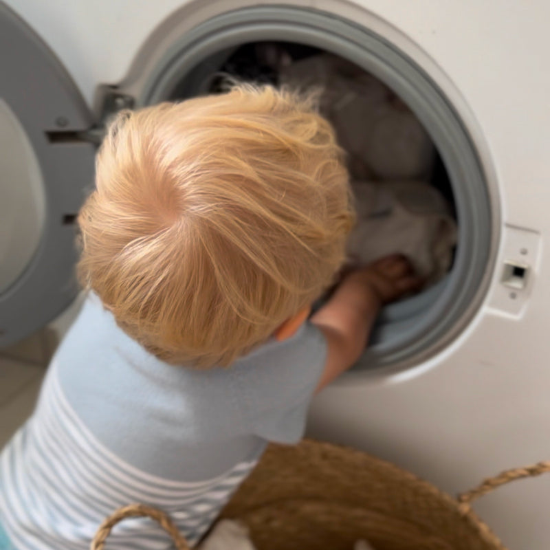 Servizio pannolini o lavaggio autonomo Bambino inserisce i pannolini Judes nella lavatrice