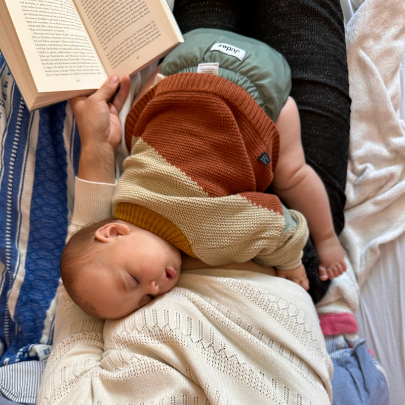 Judes Baby schläft auf Schoß Mama liest windeln Haltbarkeit