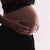 Judes Schwangere hält Bauch schwarzes Outfit Obstipation in der Schwangerschaft