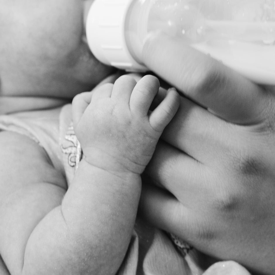 Judes Baby wird gefüttert Flaschenkind Stuhlgang