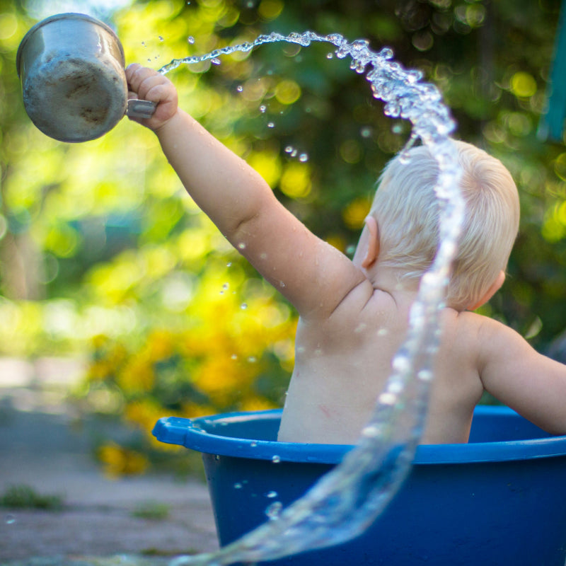 Judes Baby in Schüssel Wasser spritzt Baby Hautpflege